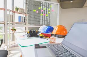 Group of safety helmet on desk of architectural at construction site, Engineer and teamwork concepts photo
