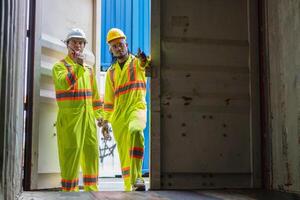 Engineer man Team in Safety Gear Inspecting Containers Box at Industrial Site, Container Yard Dock Workers Discussion at Shipping Yard photo