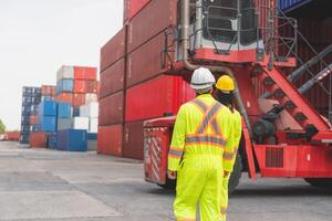 Back view of Engineer man Team in Safety Gear Control Containers Box at Container Cargo, Container Yard Workers Team Discussion at Shipping Yard photo