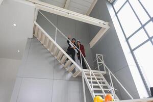 Female engineer and foreman worker checking project at building site, Engineer and builders in hardhats discussing on construction site photo