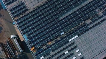 Blue solar panels on roof of building. Construction of innovative photovoltaic solar cells. Alternative source of energy. Camera moving down. Aerial view. video