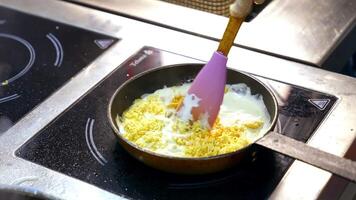 Cooking food in a frying pan. Chef is frying tasty dish in white sauce and mixing it with a scapula. Cooking delicious meal in a restaurant. video