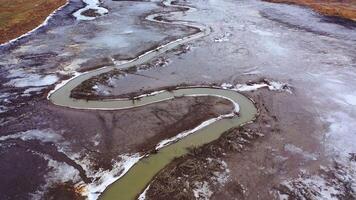 Muddy background. Dirty narrow stream of dried river. Ecological disaster. Natural problems in the world. Muddy water in tortuous river. Top aerial view. video