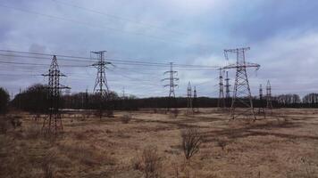High voltage electric towers on field. Transmission power lines. High voltage power line insulators. Electric towers with electric cables stretched between them, wires with high voltage current. video