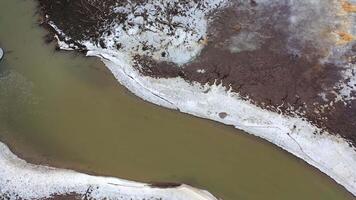 Muddy water. Flight over the dirty narrow river floating among polluted field in springtime. Ecological disaster. Aerial view. video