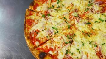 Delicious pizza. Ready pizza with melted cheese rotating on a table in pizzeria. Well baked pizza in a restaurant. Close-up. video
