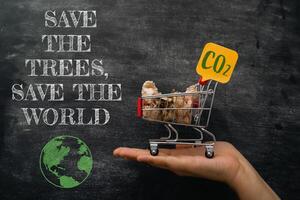 Hand holding a shopping cart with a sign that says Save the Trees photo