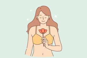 Serene woman holds spring flower and smiles, standing in bra, for metaphor of purity and innocence vector