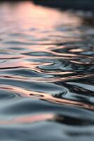 Rippling water reflects soft sunset hues in tranquil setting photo