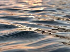 Beautiful water ripples reflecting sunlight at sunset photo