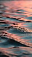 Waves reflecting colors at sunset over calm water photo