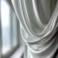Soft white fabric drapes softly near a window in natural light photo