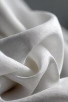 Soft white fabric draping gracefully in subtle folds and textures photo