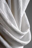 Textured white fabric draped elegantly against a dark background photo