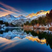 Stunning sunset reflects on serene mountain lake photo
