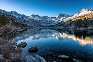 Mountain lake reflects serene snowy peaks at dawn photo