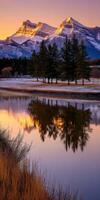 Majestic mountains reflect in calm river at sunset photo