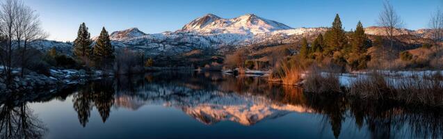 Mountain reflections over a calm lake at sunset photo