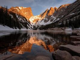 Stunning mountain lake reflecting golden sunrise light photo