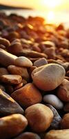 Sunlit rocks along a serene shoreline at sunset photo