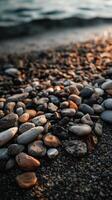 Calm shoreline with smooth pebbles during sunset photo