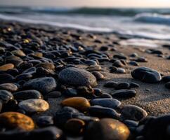 Smooth stones along a serene beach at sunset photo