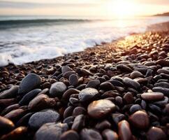 Beautiful pebble beach during sunset by the ocean photo