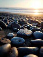 Stones on the beach at sunset with gentle waves photo