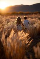 Children exploring a golden field at sunset photo