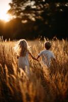 Children running through golden wheat field at sunset photo