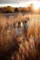 Children walking hand in hand through golden grass photo