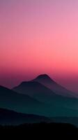 Mountain silhouettes against a pink sunset sky photo