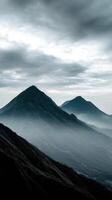 Mountain peaks rise through misty clouds at dawn photo
