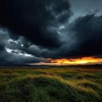 Dramatic sunset over a grassy landscape with clouds photo