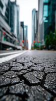 A city street with cracks in it and a city skyline in the background photo