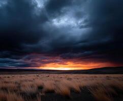 A dark sky with clouds and grass photo