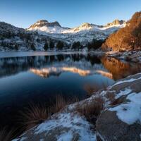 A lake surrounded by snow covered mountains photo