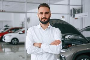 Portrait of beautiful man. Worker, in ,formal clothes is in the auto salon photo