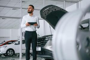 Worker in formal clothes is in the auto ,salon photo