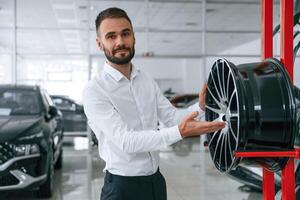Worker in formal ,clothes is in the auto salon photo