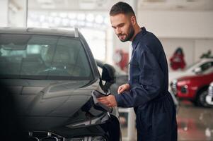 Polishing the vehicle. Car ,repairman is in the garage with automobile photo