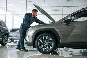 Fixing the, vehicle,. Side view. Car repairman is in the garage with automobile photo