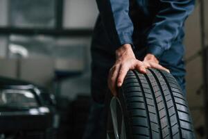 Close up view of man that is moving tire of the car photo