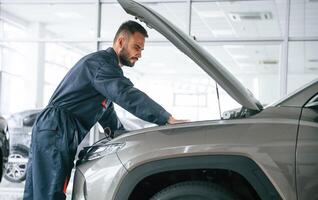 Fixing the, vehicle. Side view. Car, repairman is in the garage with automobile photo
