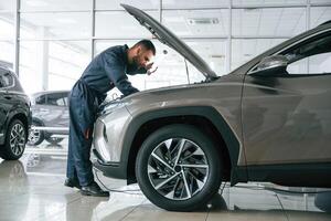 View ,from, the side. Car repairman is in the garage with automobile photo