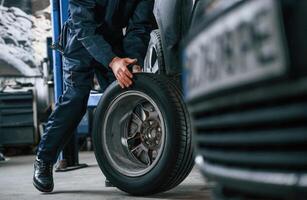 Close, up view, of man that is moving tire of the car photo