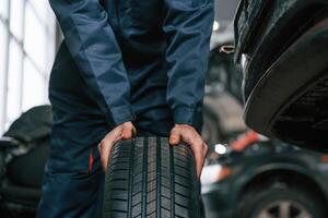 Close,, up view of man that is moving tire of the car photo