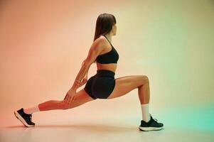 Side view, doing exercise. Young ,woman ,in fitness clothes is in the studio photo