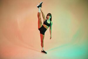 Standing ,and doing exercises. Young woman in fitness clothes is in the studio photo