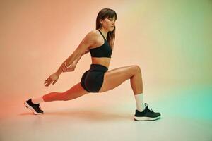 Side view, doing ,exercise. Young woman in fitness clothes is in the studio photo